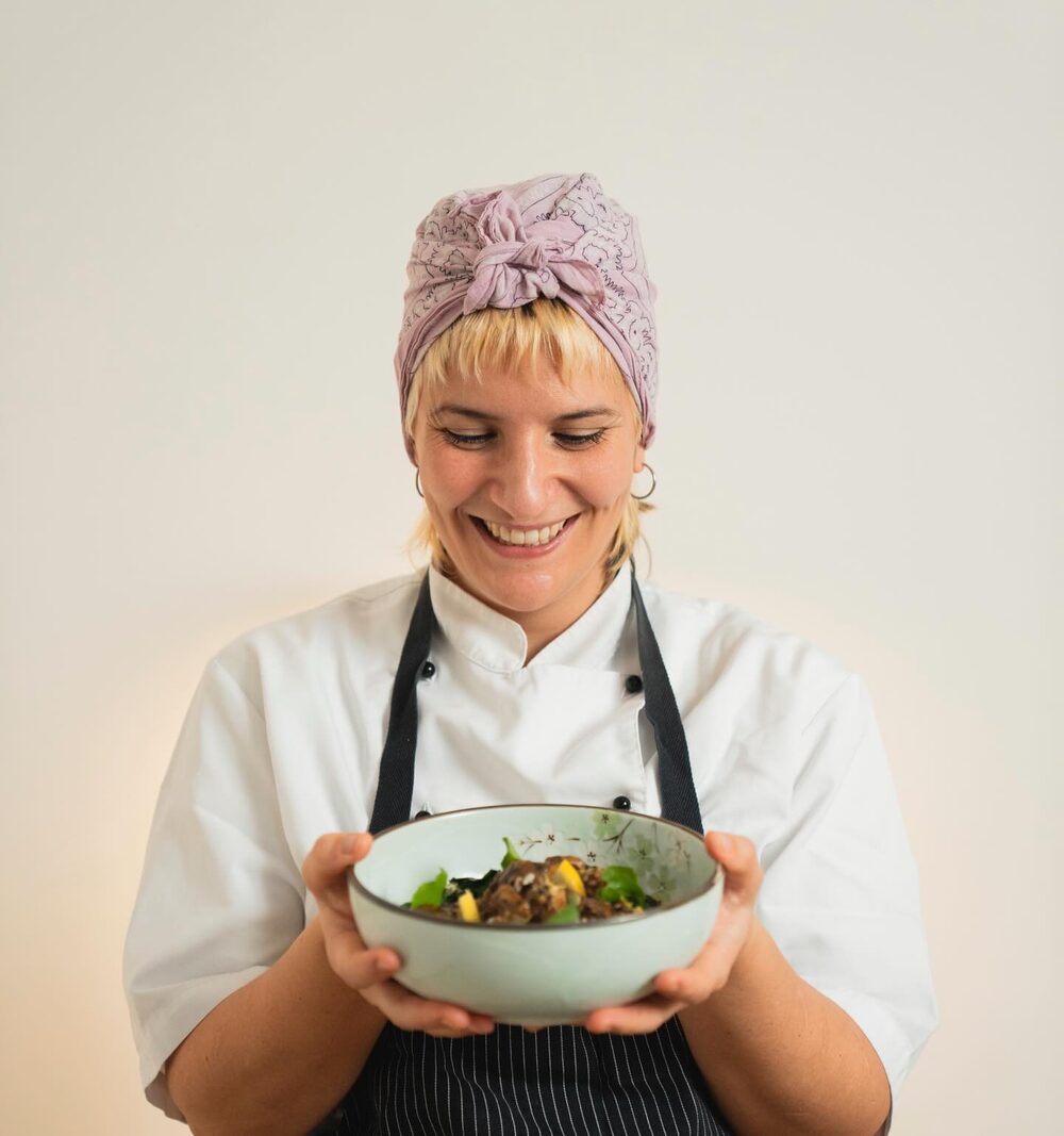 La chef Enza sorride mentre tiene tra le mani una ciotola di cibo